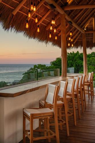 a bar with chairs and a view of the ocean at Sayulinda Hotel in Sayulita
