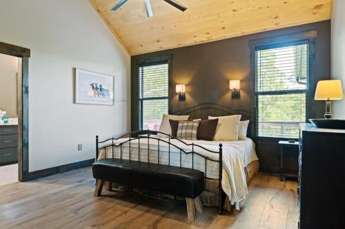 a bedroom with a bed with a bench in it at Long Ridge Lodge in Cherry Log