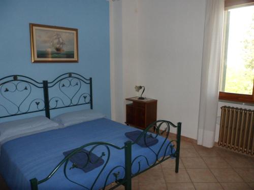 a blue bedroom with a bed and a window at Agriturismo La Quiete in Roncofreddo
