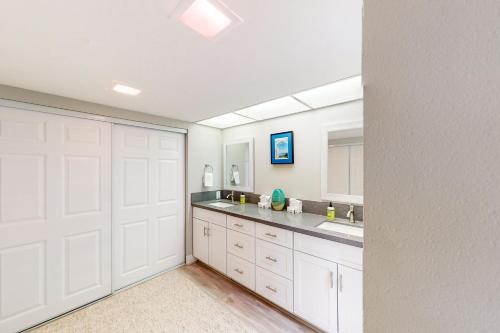 a large bathroom with white cabinets and a sink at Riviera Gardens in Palm Springs