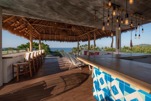 a bar with chairs and a view of the ocean at Sayulinda Hotel in Sayulita