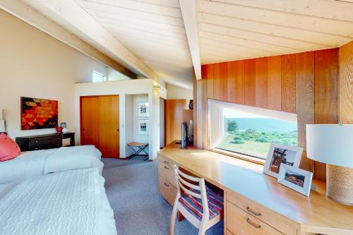 een slaapkamer met een bed en een bureau met een raam bij Just Bluffing in Sea Ranch