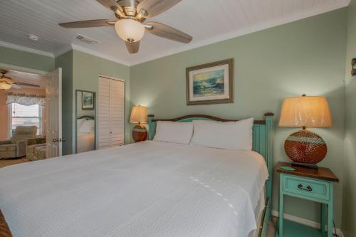 a bedroom with a white bed and a ceiling fan at Sea & Sun 204 by Vacation Homes Collection in Gulf Shores