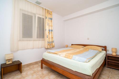 a bedroom with a bed and a window at Apartment Zuljana 10233b in Žuljana