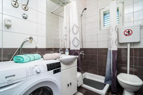 - un lave-linge dans la salle de bains pourvue d'un lavabo et de toilettes dans l'établissement Apartments by the sea Zuljana, Peljesac - 10233, à Žuljana