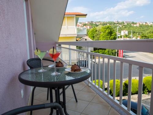 een tafel op een balkon met twee glazen wijn bij Lavish Apartment in Imotski near Blue Lake in Imotski
