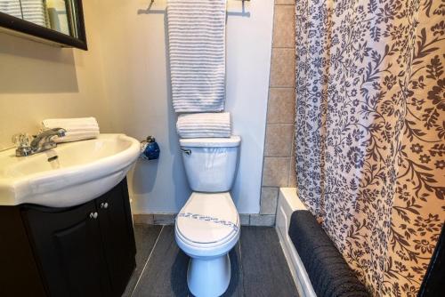 een badkamer met een toilet, een wastafel en een douchegordijn bij Studio Stays Downtown Montreal in Montreal