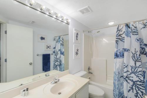 ein Badezimmer mit einem Waschbecken, einem WC und einem Spiegel in der Unterkunft Pelican Pointe 506 by Vacation Homes Collection in Orange Beach