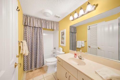 a bathroom with a sink and a toilet and a mirror at The Palms 504 by Vacation Homes Collection in Orange Beach