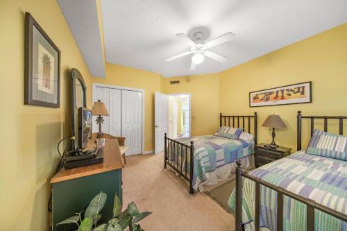 - une chambre avec 2 lits et un ventilateur de plafond dans l'établissement The Palms 504 by Vacation Homes Collection, à Orange Beach