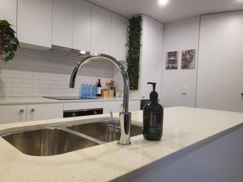 a kitchen counter with a sink with a bottle of alcohol at 2BR@Luxury&Stylish Top Floor Apt,Pool,Parking,View in Harrison