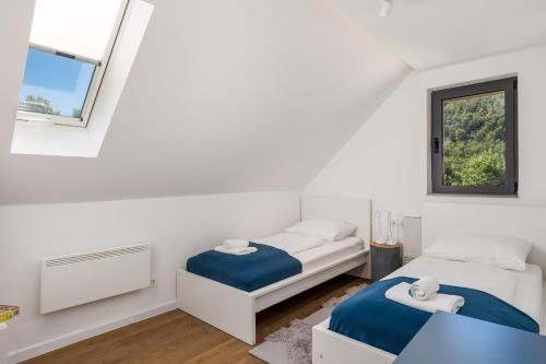 2 Betten in einem weißen Zimmer mit Fenster in der Unterkunft Family friendly house with a parking space Baske Ostarije, Velebit - 21330 in Brušane