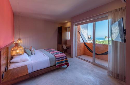 a bedroom with a bed and a view of the ocean at Sayulinda Hotel in Sayulita