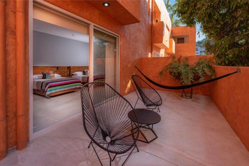 a patio with two chairs and a hammock on a balcony at Sayulinda Hotel in Sayulita