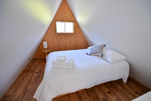 a bedroom with a white bed in a attic at OTIS Nature in Lamarche