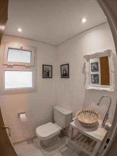 a bathroom with a toilet and a sink and a mirror at Casa de Colores in Torres