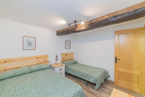 1 Schlafzimmer mit 2 Betten und einer Holztür in der Unterkunft Casa Luna in Losar de la Vera