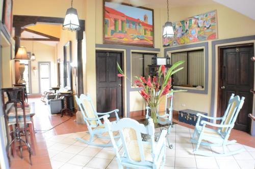 a room with chairs and a table with a vase of flowers at Hotel Los Balcones de Chinandega in Chinandega