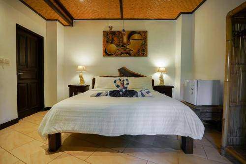 a bedroom with a large white bed in a room at Istana Balian - Boutique Hotel Resort in Selemadeg