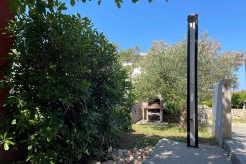 a large bush next to a building with a fireplace at Apartments by the sea Povljana, Pag - 21144 in Povljana