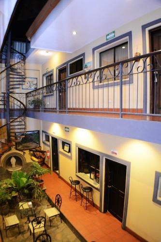 an apartment building with a balcony and tables and chairs at Hotel Los Balcones de Chinandega in Chinandega