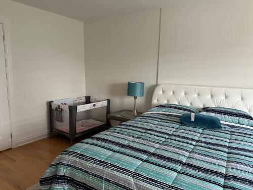 een slaapkamer met een bed met een blauw dekbed bij Beautiful townhouse. in Vaughan