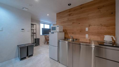 a kitchen with a refrigerator and a counter top at Relax Hotel Takayama Station in Takayama