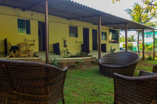 a house with two wicker chairs in front of it at Pousada Shalon Adonai Noronha in Fernando de Noronha
