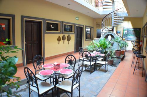 a restaurant with tables and chairs and a staircase at Hotel Los Balcones de Chinandega in Chinandega