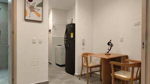 a room with a refrigerator and a table and chairs at Apartasuite moderno y elegante en Playa Salguero in Gaira
