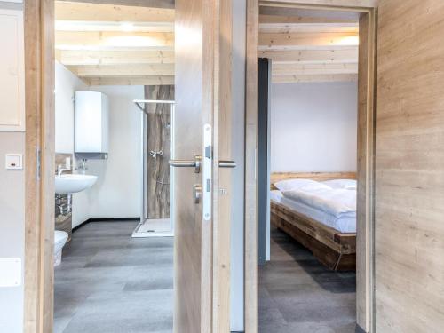 a bedroom with a bed and a door leading to a bathroom at Lakeside Comfort in Hallschlag in Hallschlag