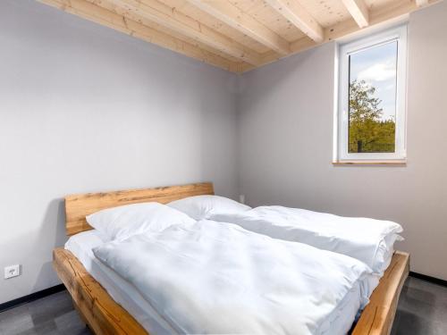 a bedroom with a bed with white sheets and a window at Lakeside Comfort in Hallschlag in Hallschlag