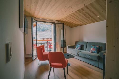 a living room with a table and chairs and a couch at Terra-Beka Lodge in La Chapelle-dʼAbondance