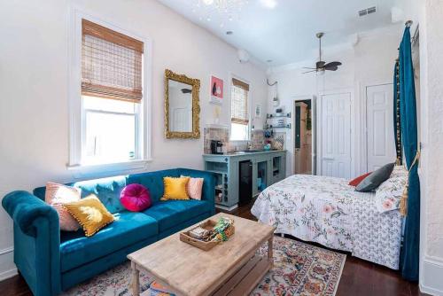 a living room with a blue couch and a bed at Historic Victorian Studio Near City Park NOMA Bayou St John in New Orleans