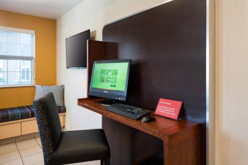 a desk with a computer monitor and a keyboard at TownePlace Suites Los Angeles LAX Manhattan Beach in Hawthorne