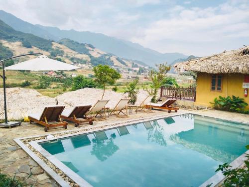 a swimming pool with lounge chairs and a house at Sapa Eco Homestay in Sa Pa