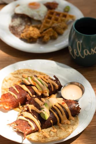 two plates of food on a table with a plate of food at Boskenvid Hotel - Romantic Treehouses & Skypool in Valle de Guadalupe