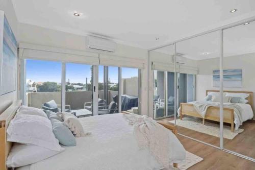 um quarto com uma cama grande e uma varanda em The Haven on Blue Bay em Mandurah