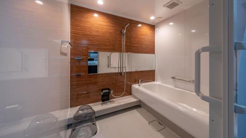 a bathroom with a shower and a tub and a sink at Relax Hotel Takayama Station in Takayama