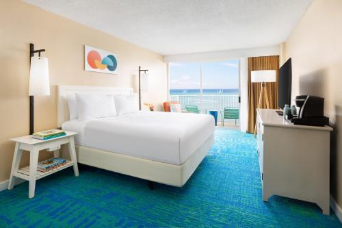 a hotel room with a bed and a balcony at The Twin Fin Hotel in Honolulu