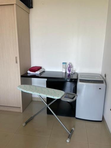 a desk with a table next to a small refrigerator at Stylish 2 Bedroom Penthouse Apt, Newly Refreshed, 50 Mbps, Pool, Gym, Resto in Kuta