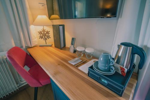 a desk with a coffee maker and a red chair at Terra-Beka Lodge in La Chapelle-dʼAbondance