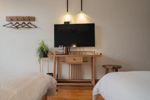 a room with two beds and a flat screen tv at 张家界天门山伴田居民宿 in Zhangjiajie