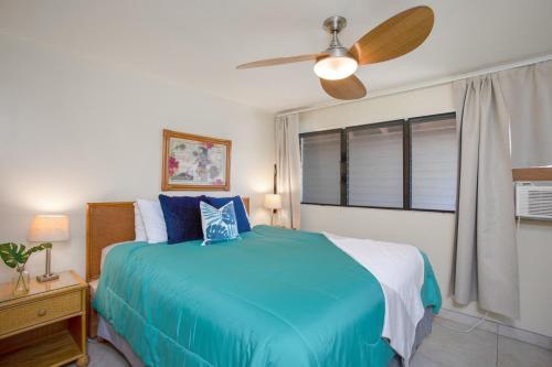 1 dormitorio con 1 cama azul y ventilador de techo en Beautiful 1 Bedroom Condo with Ocean Views | Oceanfront en Kihei