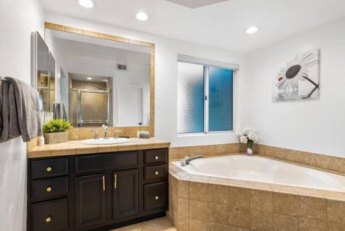 a bathroom with a large tub and a sink at Desert Falls Diamond - pool, spa, golf, views! in Palm Desert