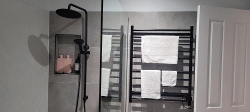 a bathroom with a shower with towels on a rack at Boutique Beach House in the HEART of St. Kilda in Melbourne