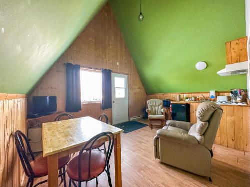 a living room with a green ceiling and a table and chairs at OTIS Nature in Lamarche