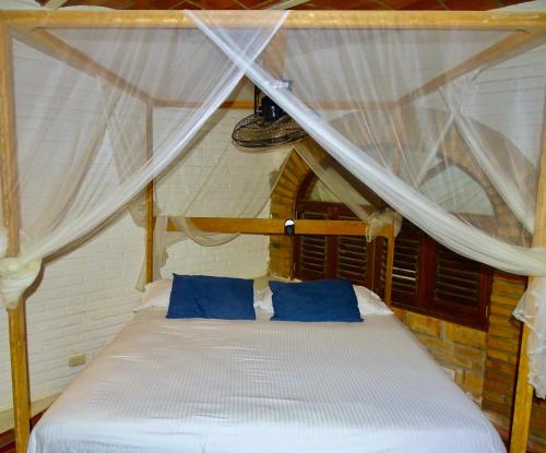 a bed with blue pillows in a room at Sayulita Beach House Hotel in Sayulita
