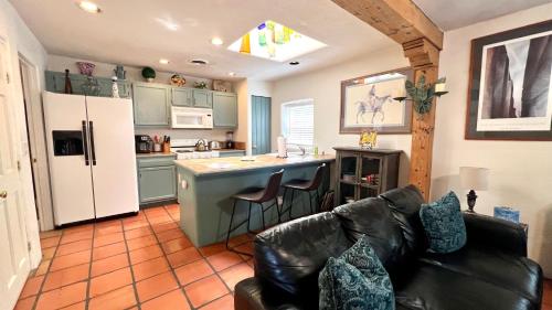 a living room with a couch and a kitchen with a refrigerator at Casas de Guadalupe - Sante Fe Vacation Rentals in Santa Fe