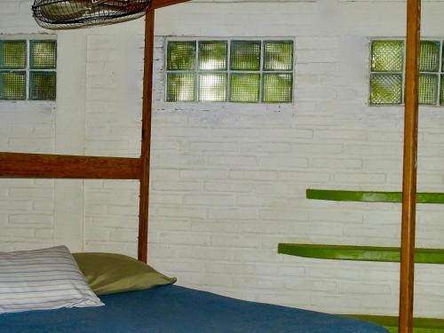 a bedroom with a bunk bed and three windows at Sayulita Beach House Hotel in Sayulita